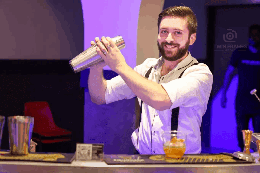 Bartender mixing drinks using the shaker to serve the guest in an event catered by the mobile bar.