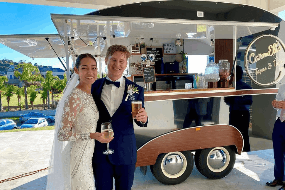 Newly wed couple having their drinks being served by the mobile bar of CarmEli Catering.