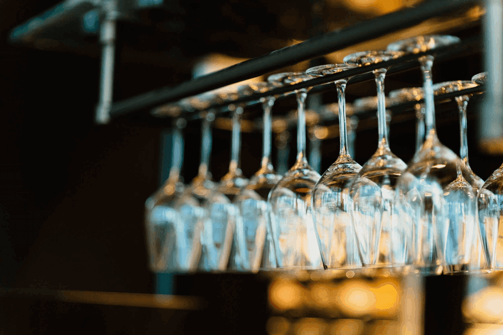 Wine glasses hanging from the bar rack.