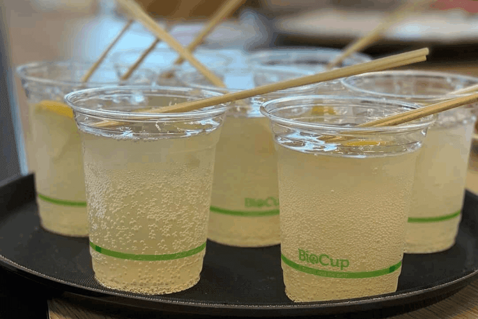 Drinks in biodegradable cups served from the mobile bar of Hutdog Catering + Events in an event.