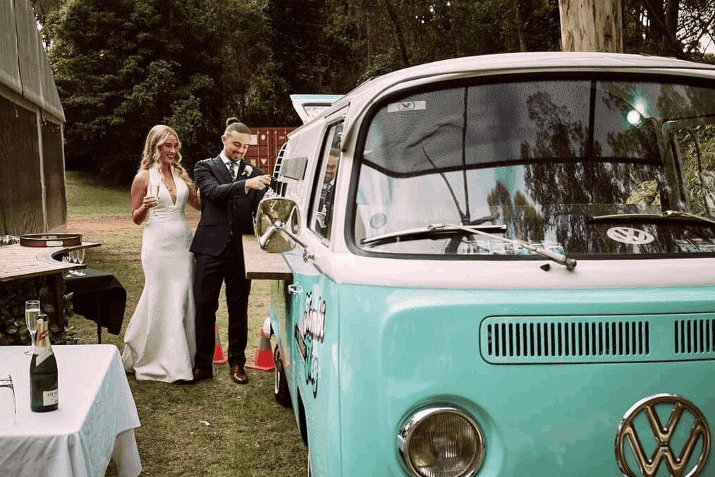 Bride and groom getting drinks from the mobile bar of Kombi Keg South Coast in their wedding.