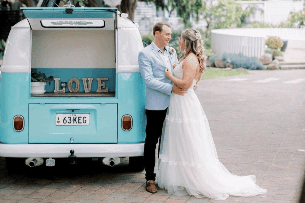 Newly wed couple posing for a photo with the mobile bar of Kombi Keg Sunshine Coast.