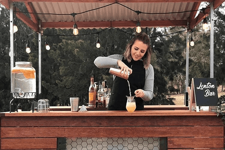 Bartender mixing drinks in the mobile bar in an event.