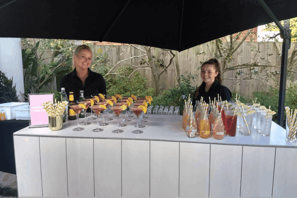 Bartender and hired staffs serving drinks from the mobile bar of Melbourne Mobile Bars.