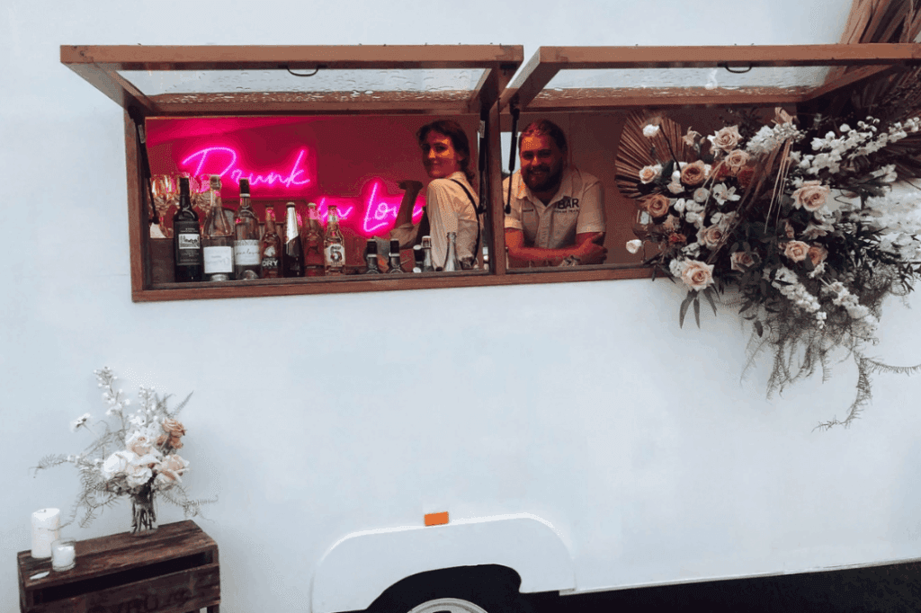 Two staffs of The Cocktail Camper setting up the mobile bar for an event.