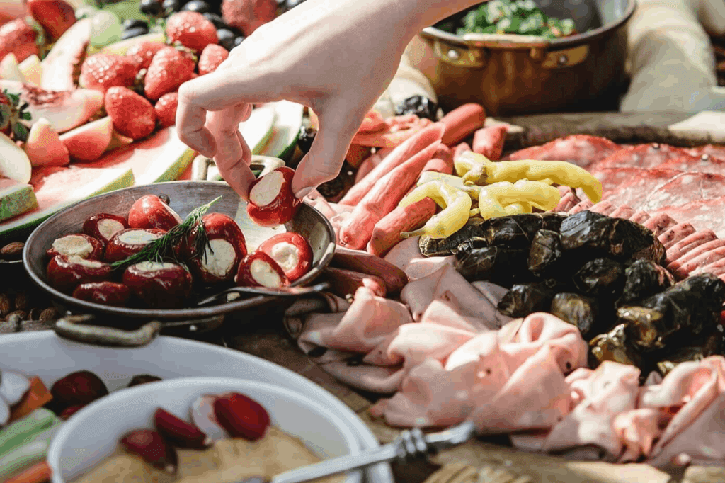 A table setup filled with fruits, cheese. and other type of finger foods in an event.